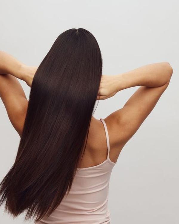 Sleek straight dark hair with mirror shine, seen from the back